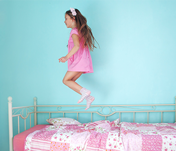 petite fille sautant sur un lit