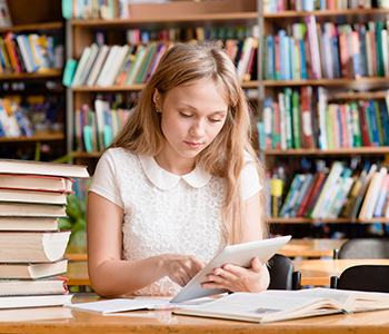 Adolescente r&eacute;vise sur tablette