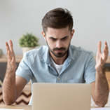 Homme énervé devant son ordinateur qui ne s'allume plus