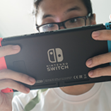 jeune homme joue à la Nintendo Switch