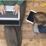 père et enfant sur smartphone et tablette