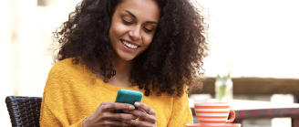 jeune femme sourit à son téléphone