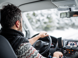 Homme conduisant une voiture en hiver