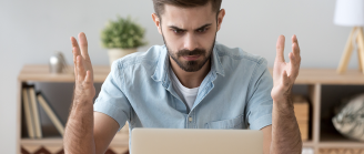 Homme énervé devant  son ordinateur qui ne s'allume plus