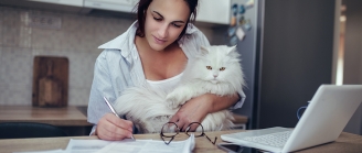 femme travaille avec son chat dans les bras