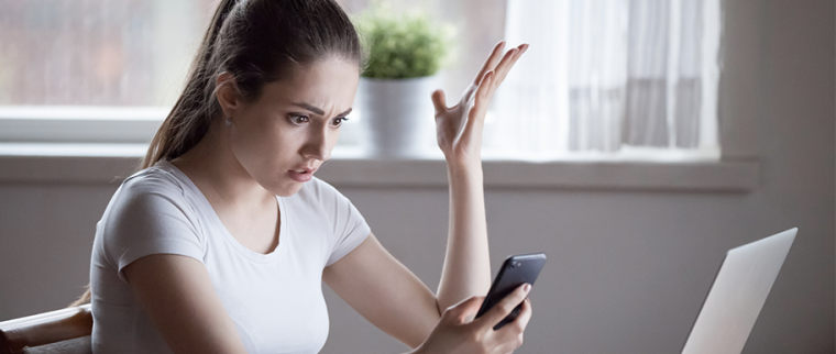 femme énervée devant son smartphone bloqué