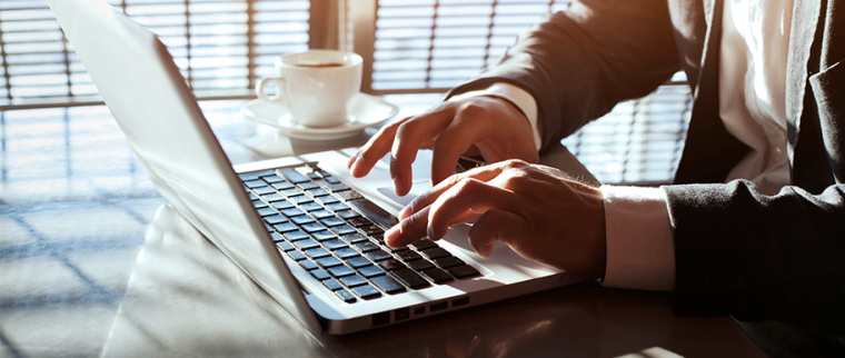 Un homme tape sur le clavier de son ordinateur portable