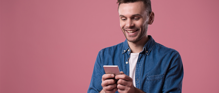 homme souriant avec son smartphone dans les mains