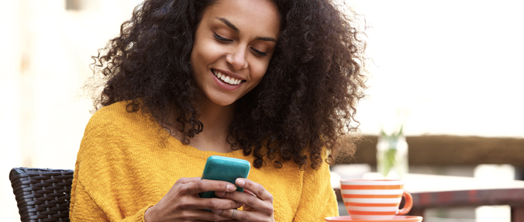 jeune femme sourit à son téléphone
