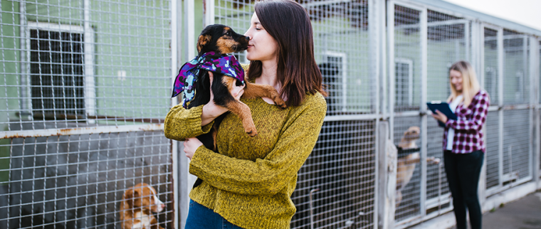 femme avec chien adopt&eacute; dans les bras