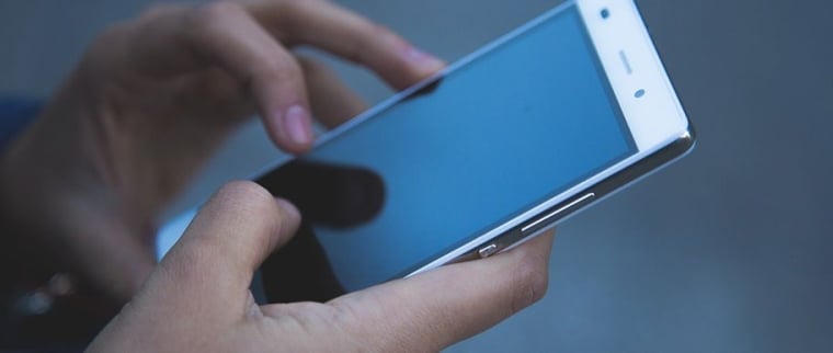 Un homme tient son  Android en main